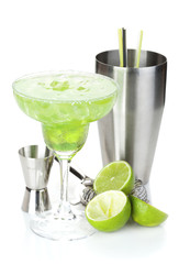 Classic margarita cocktail with salty rim, limes and drink utens