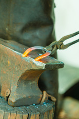 Hammering glowing steel - to strike while the iron is hot.
