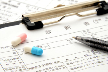 医療イメージ―診断書の上のカプセル