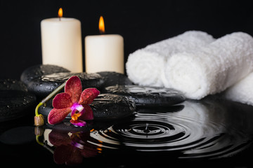 spa concept of zen stones with drops, purple orchid (phalaenopsi