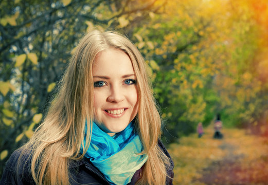 Young pretty blonde woman in the autumn park