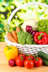 Fresh vegetables in white wicker basket on bright background