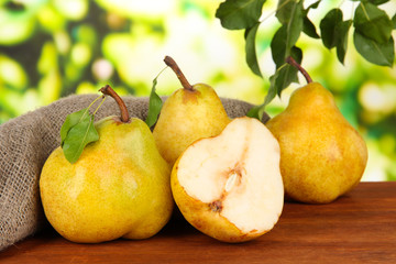 Juicy pears on table on bright background