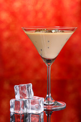 Baileys liqueur in glass on red background