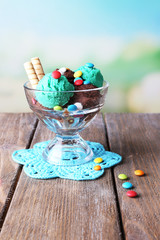Chocolate ice cream with multicolor candies and wafer rolls in