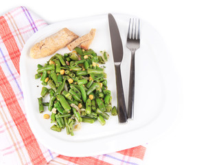 Salad with green beans and corn on plate, isolated on white