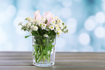 Beautiful flowers on table, on bright background