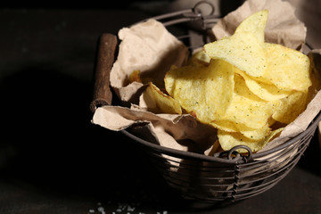 Tasty potato chips in metal basket