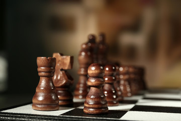 Chess board with chess pieces on brown background