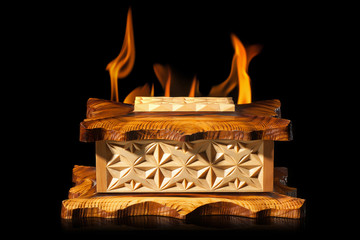 old brown wooden casket in fire flame on black background