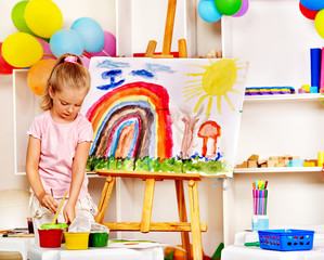 Child painting at easel.