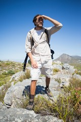 Handsome hiker standing at the summit looking around