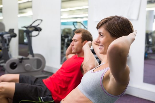 Fit couple doing sit ups on exercise ball