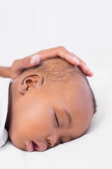 Fototapeta na wymiar Adorable baby boy sleeping with fathers hand on head