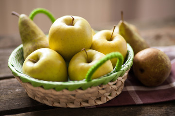 Naklejka na ściany i meble Fresh green apples and pears on a wooden table