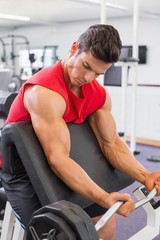 Obraz na płótnie Canvas Muscular man lifting barbell in gym