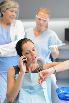 Impatient Woman Patient On Phone At Dental Clinic