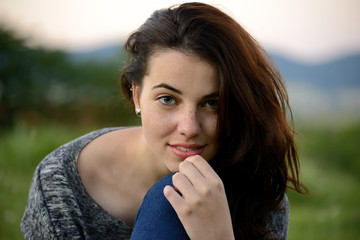 Beautiful dusk summer portrait of a young freckled young woman