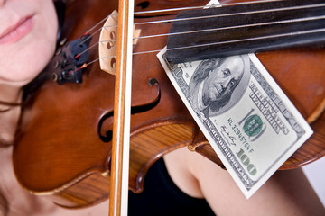 woman plays the viola with banknotes