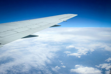 Obraz premium Wing of the plane on blue sky background and snowy mountains,