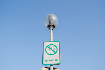 Fototapeta na wymiar warning sign on littering streets on street lamp