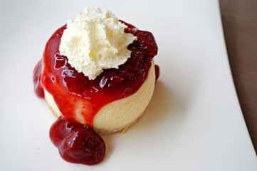 Strawberry cheesecake with wipcream on white plate