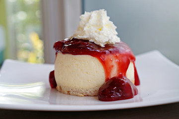 Strawberry cheesecake with wipcream on white plate
