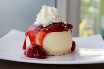 Strawberry cheesecake with wipcream on white plate