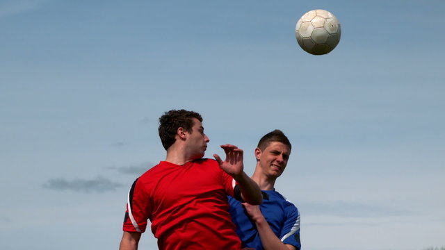 Football players jumping up and tackling for the ball
