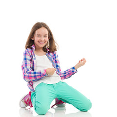 Smiling girl playing the air guitar