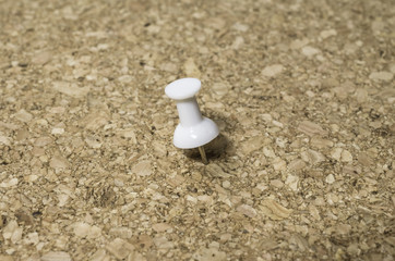 white pin on a cork board