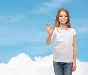 little girl in white t-shirt showing ok gesture