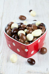 chocolate covered nuts and raisins in a heart-shaped bowl on woo