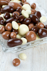 chocolate covered nuts and raisins on wooden surface