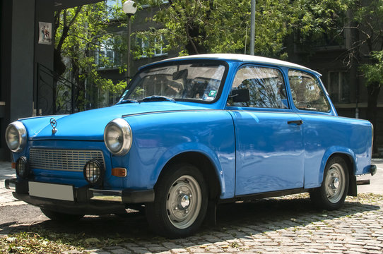 Blue vintage restored Trabant car on paved street
