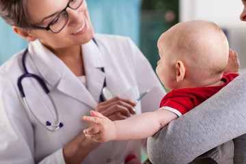 Pediatrician doctor examining little baby