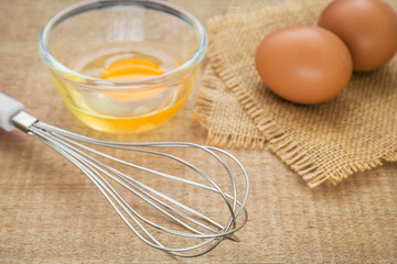 Metal whisk and fresh egg