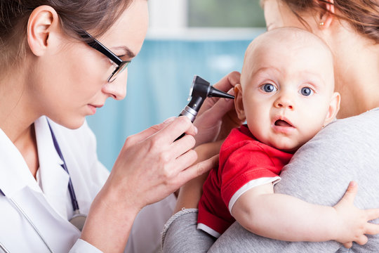 Doctor Examining Baby Boy With Otoscope