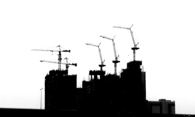 Construction site with cranes on silhouette background