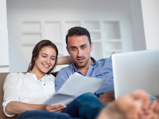 relaxed young couple working on laptop computer at home