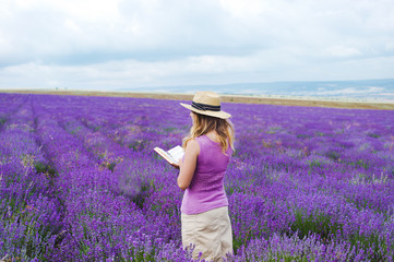 Woman in lavender field with book