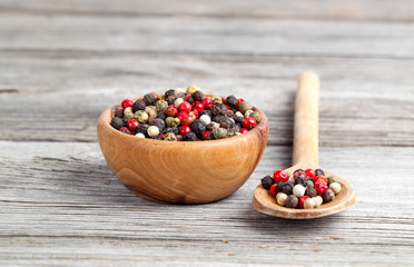 Colored Pepper in the wooden bowl, on wooden board