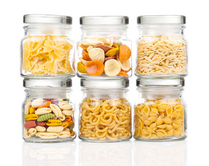 the various raw pasta in a glass jar,  isolated on white backgro