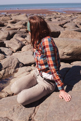 Young woman sitting on the beach