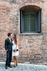 Fototapeta na wymiar Loving young couple outside an old brick building