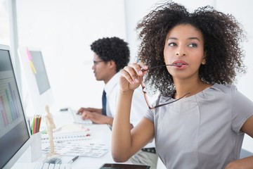 Young editor thinking at her desk