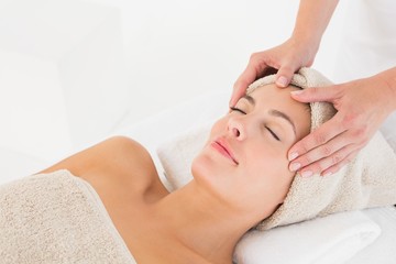 Fototapeta na wymiar Attractive woman receiving facial massage at spa center