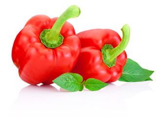Two Sweet Red Peppers with green leaves isolated on a white back