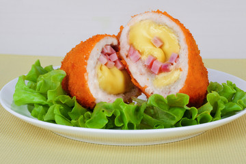 chicken cutlet with cheese, ham and salad