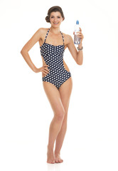 Full length portrait of woman in swimsuit with bottle of water